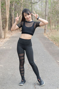 Full length portrait of young woman standing outdoors