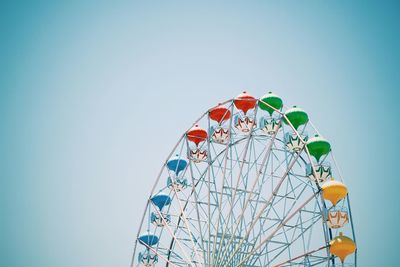 Low angle view of ferris wheel against blue sky