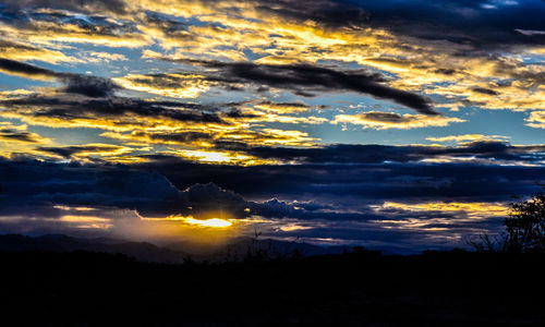 Silhouette of landscape against cloudy sky