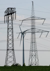 Low angle view of electricity pylon on field