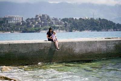 Woman in sea against sky