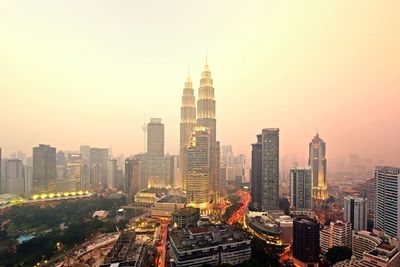 Aerial view of buildings in city against clear sky