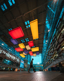 Low angle view of people walking in illuminated city