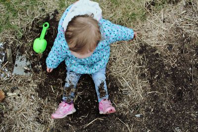 High angle view of girl with arms raised on field