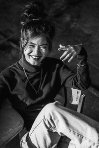 Portrait of a smiling young woman sitting outdoors