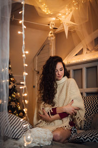 Young woman sitting in illuminated room