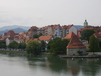 River amidst buildings in city against sky