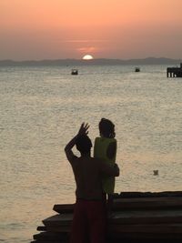 Silhouette of man standing on boat at sunset