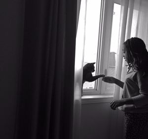 Girl and cat shaking hands at home