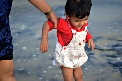 Cropped image of woman holding daughter at beach