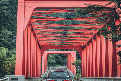 Car on red metallic bridge