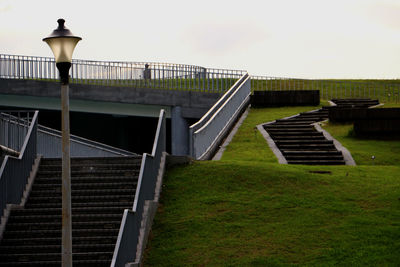 Staircase by street light against sky