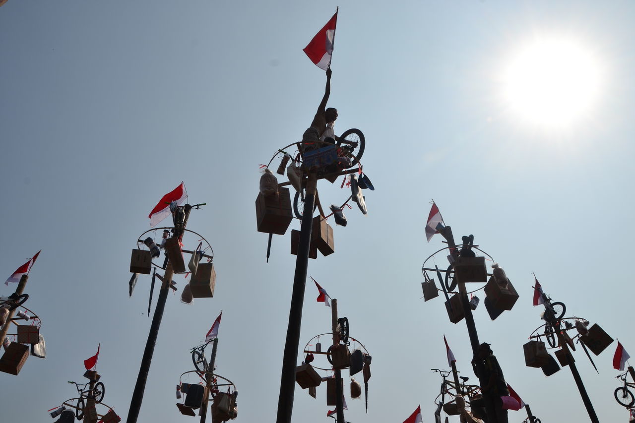 LOW ANGLE VIEW OF FLAGS AGAINST CLEAR SKY DURING SUNNY DAY