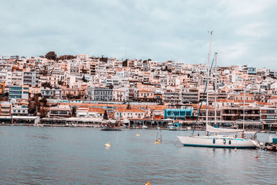 Aerial view of townscape by sea against sky