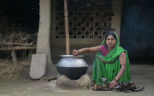 Woman making food on traditional chulha or firewood