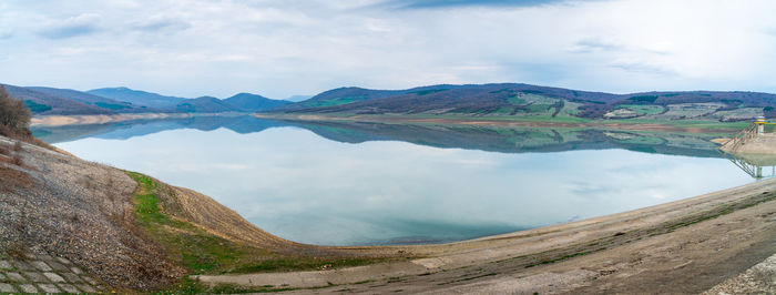 Scenic view of lake against cloudy sky