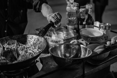 Midsection of man preparing noodles in wok