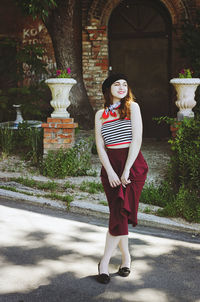 Portrait. young, happy, elegant redhead curly woman, girl in hat, casual clothes. french style. city