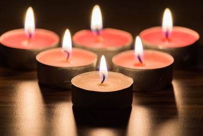 Close-up of lit tea light candles on table