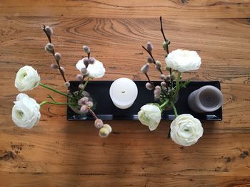 Directly above shot of flower vases with candles on table