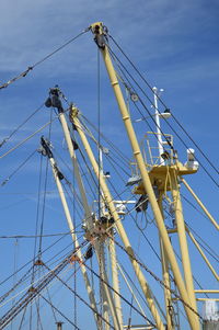 Low angle view of ship masts against blue sky