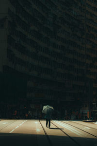 Woman walking on street amidst buildings in city