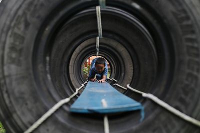 Boy playing in tunnel at playground