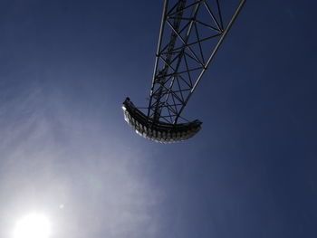 Low angle view of silhouette communications tower against sky