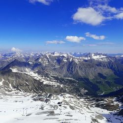 Scenic view of snowcapped mountains against blue sky