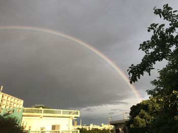 Low angle view of rainbow over buildings in city