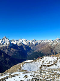 Scenic view of snowcapped mountains against clear blue sky