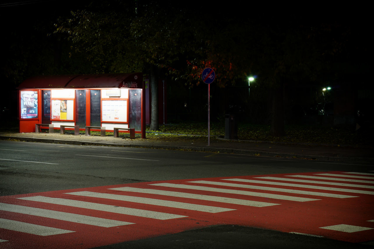 ROAD BY BUILDING AT NIGHT