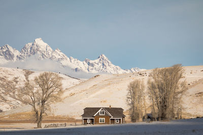 House on snowcapped mountain against sky