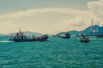 Boats sailing in sea against sky