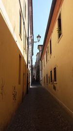 Alley amidst buildings against clear sky