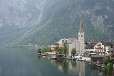 Buildings by lake against mountain