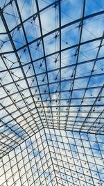 Low angle view of modern building against blue sky