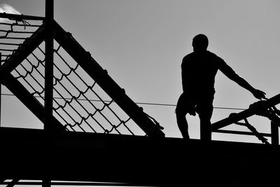 Low angle view of silhouette man against clear sky