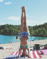 Woman doing handstand at beach