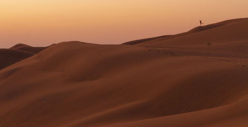 Ballet pose on the dunes at sunset