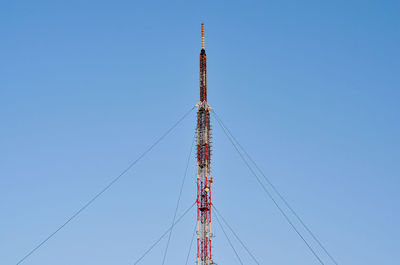 Low angle view of crane against clear blue sky