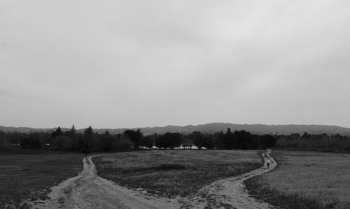 Dirt road passing through field