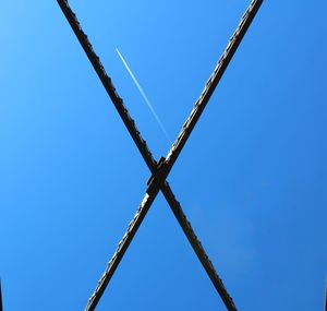 Low angle view of power lines against clear blue sky