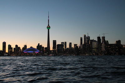 Panorama of the toronto skyline from center island at dusk, with lake ontario in the foreground.