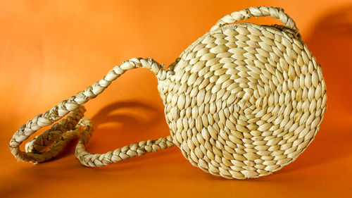 Close-up of rope on table against orange background