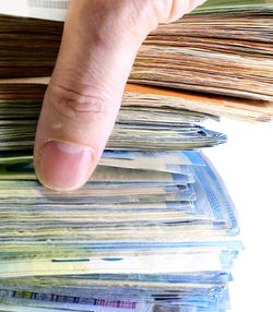 Close-up of hand holding paper stack