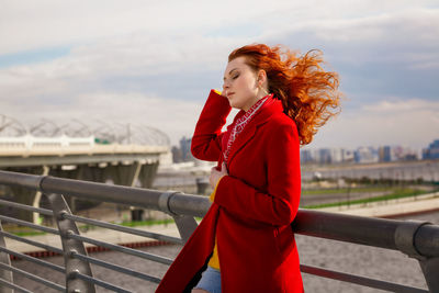 Woman wearing winter coat standing against sky