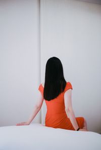 Rear view of woman sitting on floor