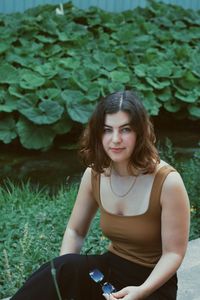 Portrait of beautiful young woman with plants in foreground