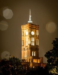 Low angle view of illuminated clock tower against sky